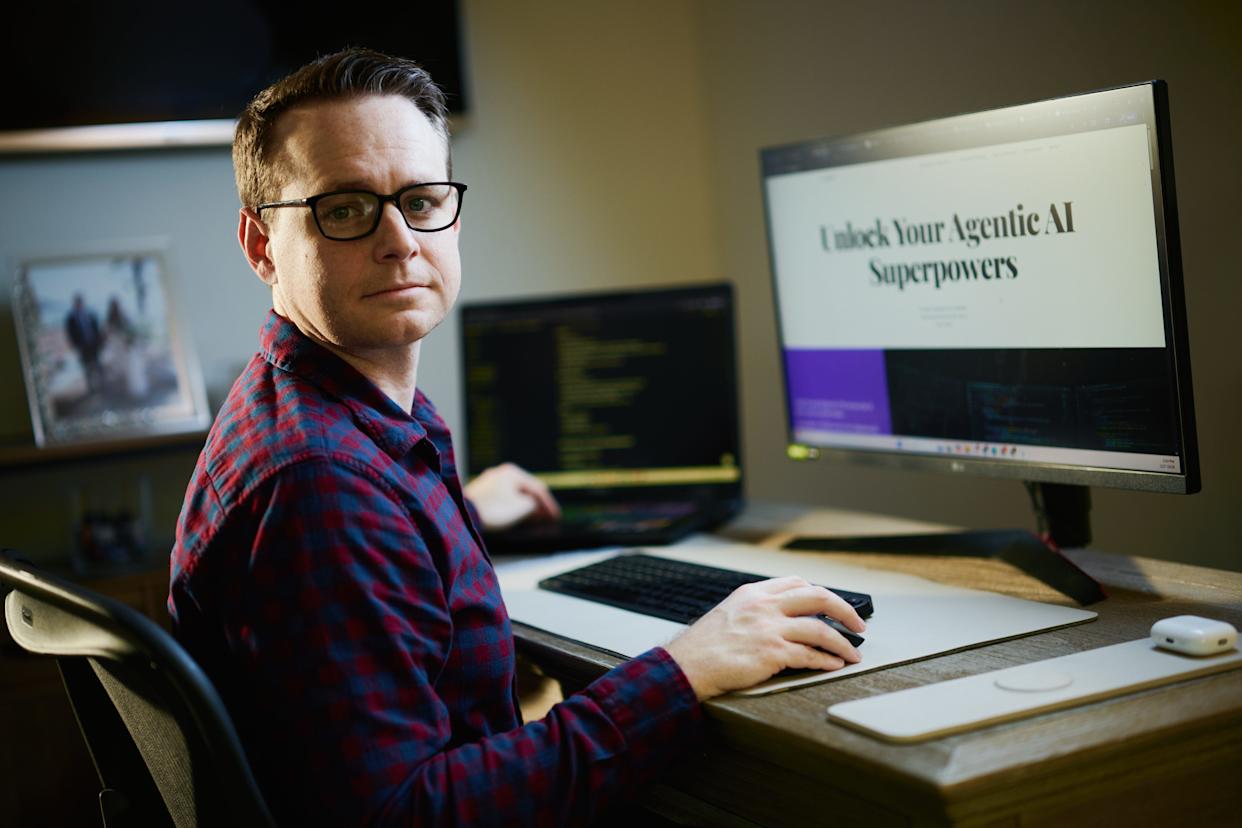Justin Parnell at his desk with an agentic AI presentation on screen